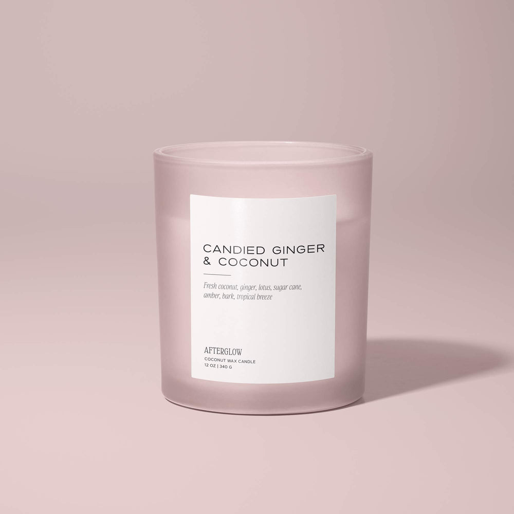 Afterglow's Candied Ginger & Coconut jar candle with a pink background